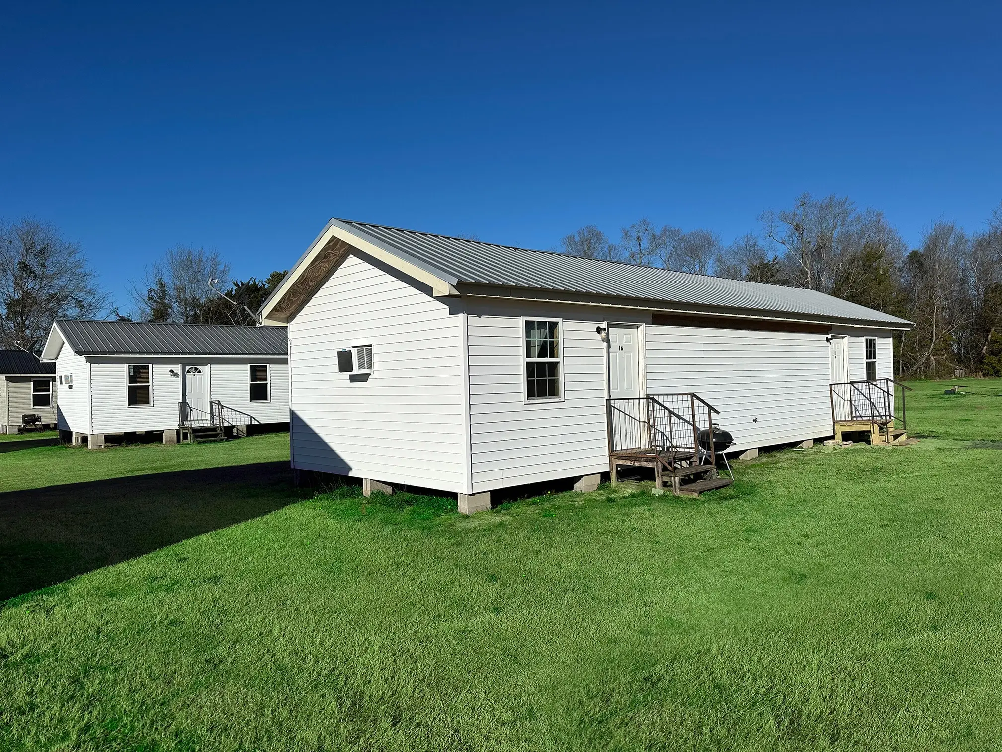 White furnished rental cabins with metal roofs at Vogtle Ranch